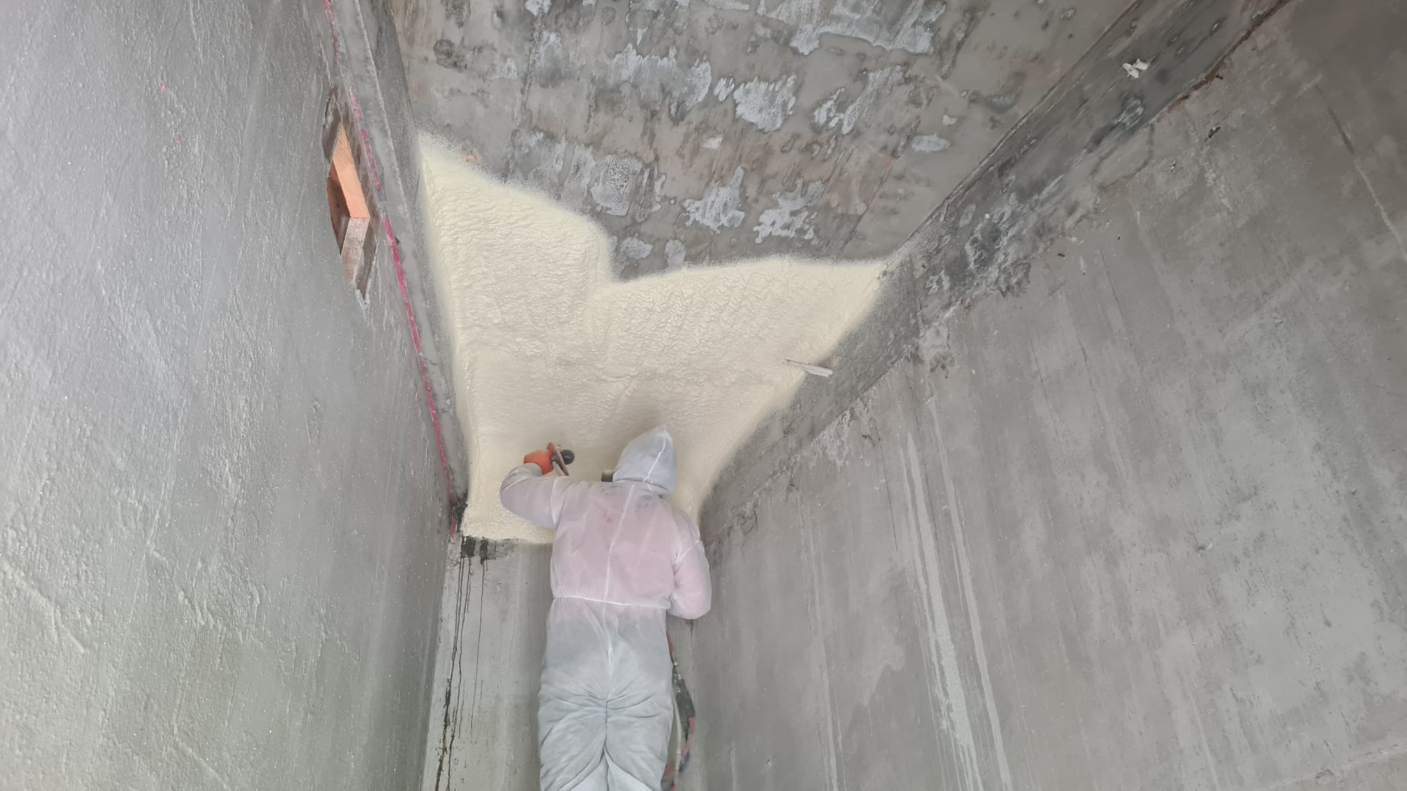 Enverge Nexseal LE closed-cell spray foam being applied to a concrete soffit