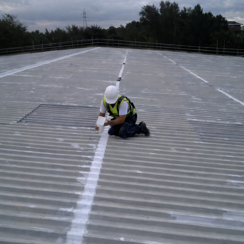 Worker applying cut edge corrosion treatment to metal roof lap joints