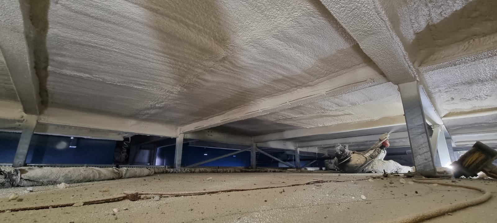 Industrial corrugated metal soffit underside before spray foam insulation — exposed thermal bridges