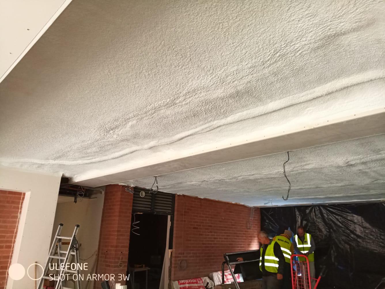 Corrugated metal industrial roof underside with closed-cell foam insulation