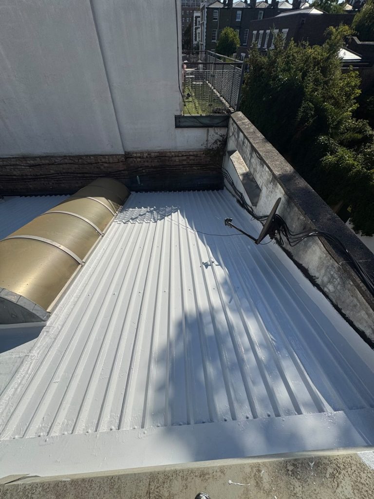 First full coat of white S42 silicone going on over the prepared profiled roof.