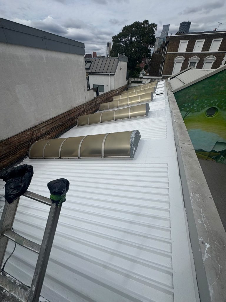 Completed GacoFlex S42 white silicone coating on a profiled metal roof between rooflights.